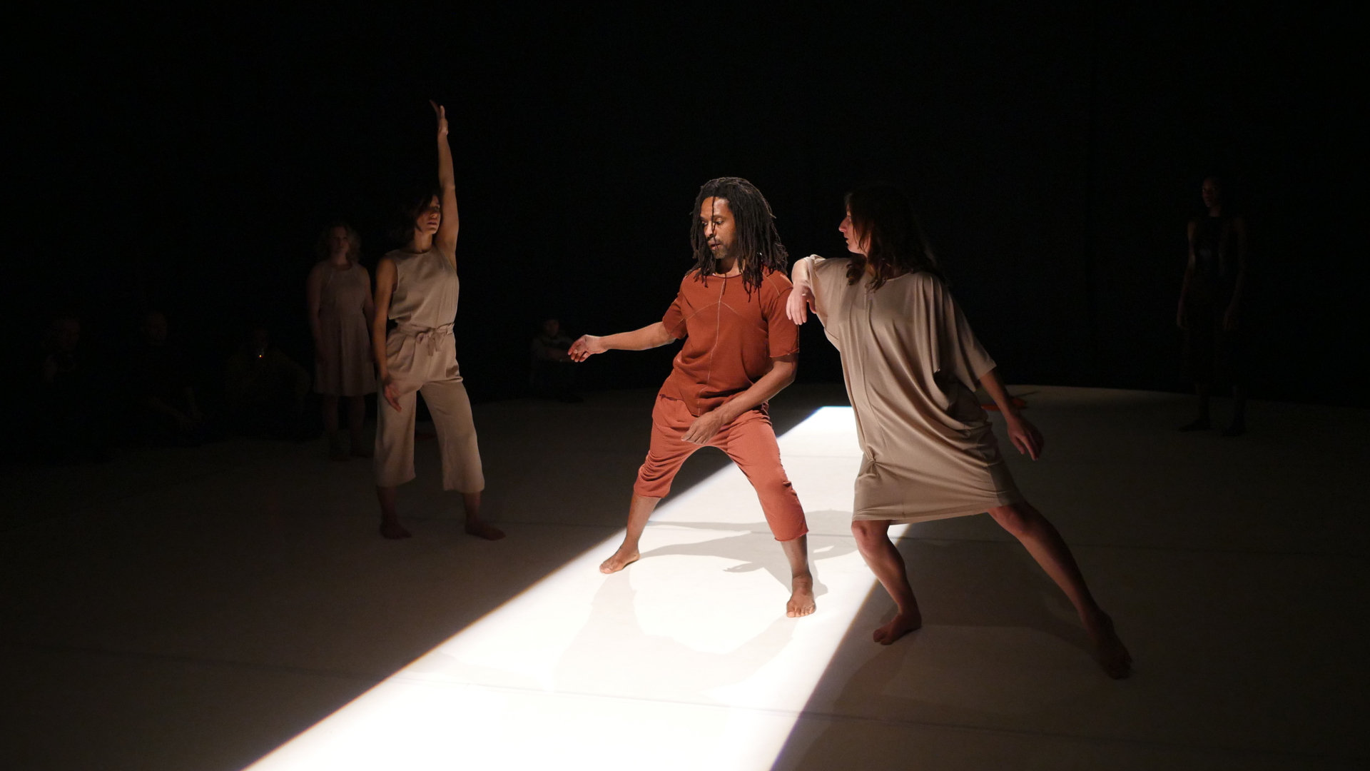 Four dancers dance on stage; they have different costumes in contemporary style.